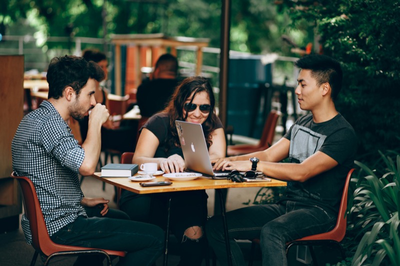 Students collaborating over coursework at a cafe